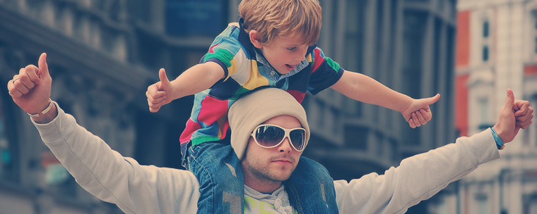 egy kisgyerek ül az apja nyakában