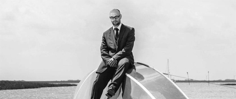 dr. Nyeste Gábor az fps ügyvezetője öltönyben ül egy süllyedő vitorláshajón