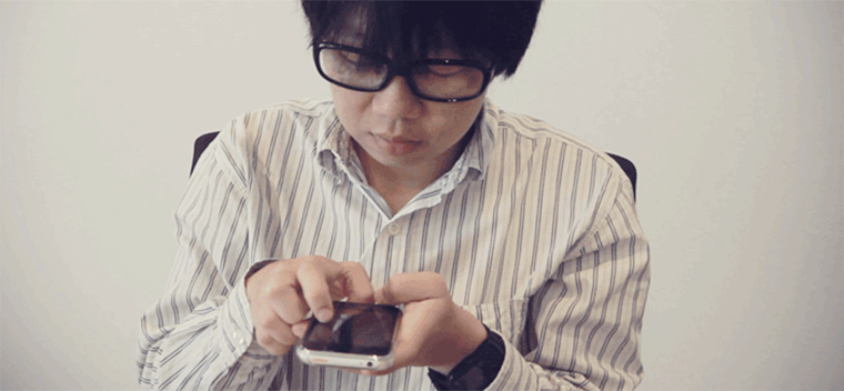 egy ember nyomkodja a mobilját fotó